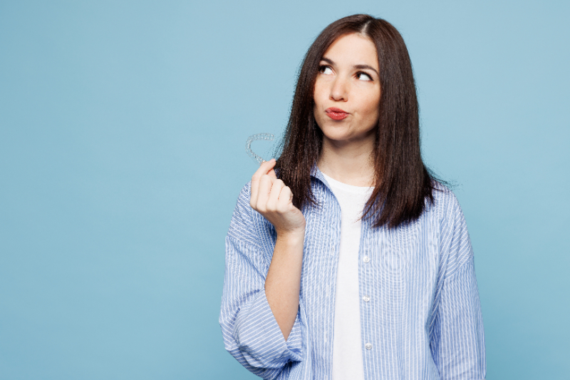 インビザラインの装置をつけたまま食事をするリスクを考える女性