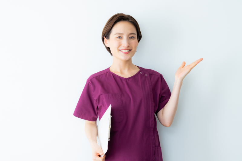 歯医者で定期的に検診を受けたほうがよい理由を伝える歯科衛生士の女性