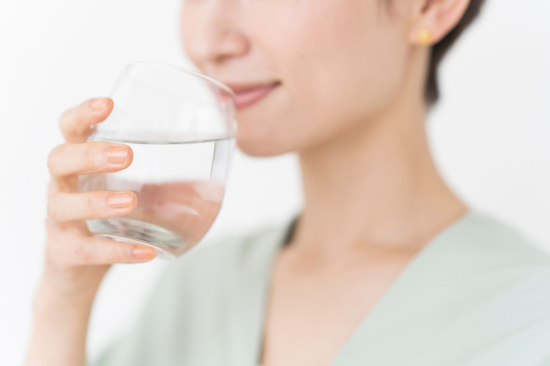 マウスピースを装着したまま水を飲む女性