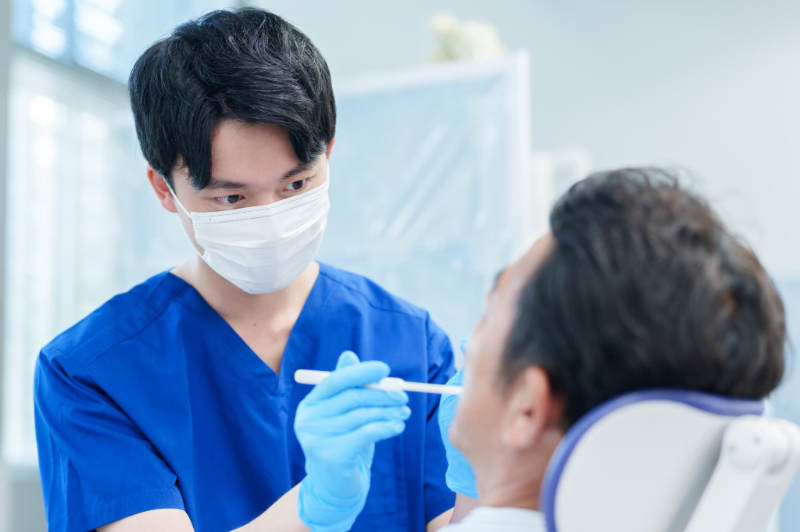 根管治療の仮蓋が外れて歯科医に診てもらう男性