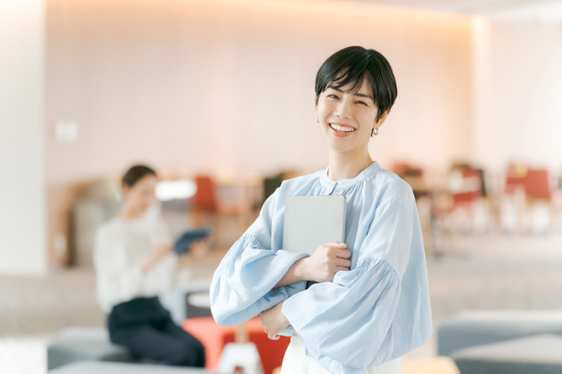 パソコンを抱えた笑顔のビジネスウーマン