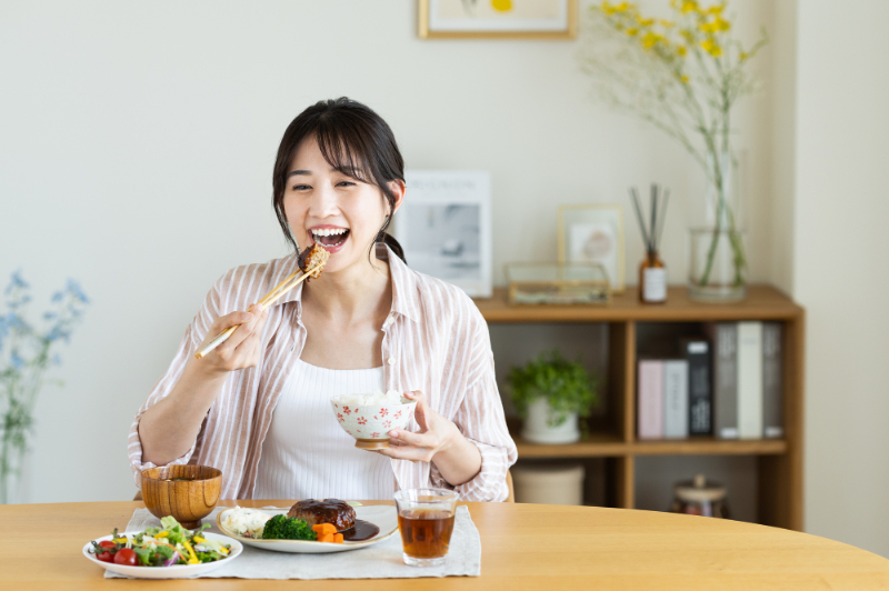 銀歯の下の虫歯を治療して食事を楽しむ女性