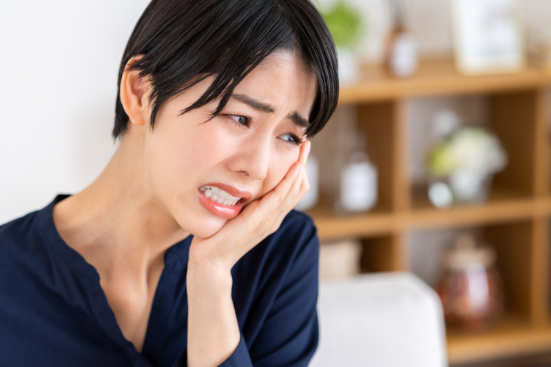 しみるような歯痛を感じる女性