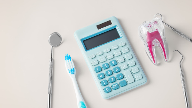 歯の模型と計算機と歯のクリーニング用の器具